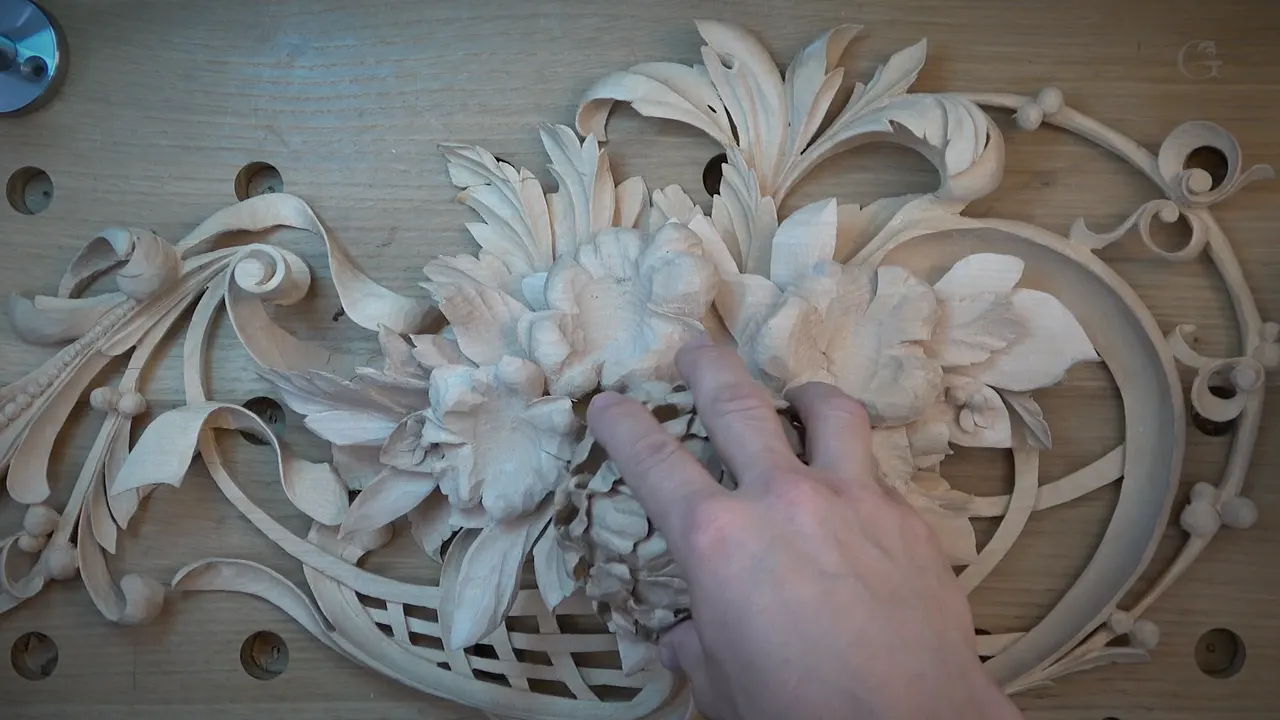 The finished peony set into the carved panel it was made for, among acanthus scrolls and a lattice basket.