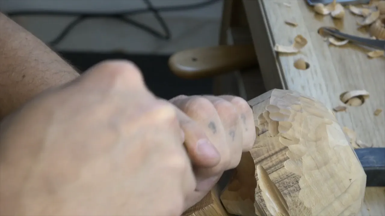 Hands turning the roughed blank over to look along its curve.