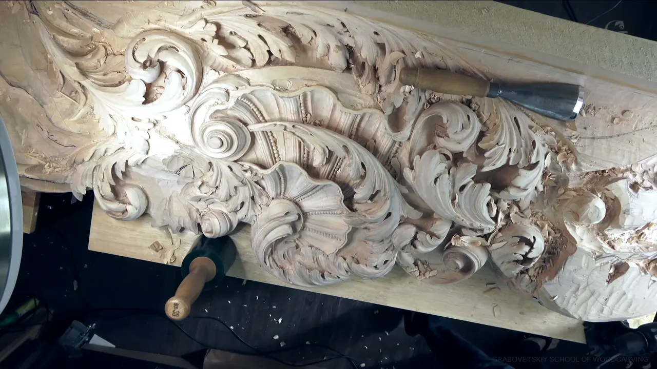 The whole ceiling board on the bench, a big gouge lying across its carved leaves.