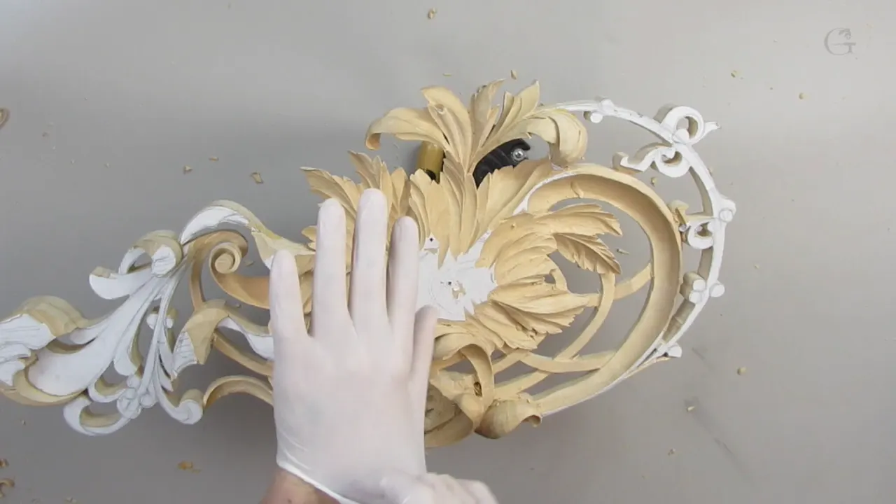 White gloved hand held flat beside the pierced panel at workshop thirteen.