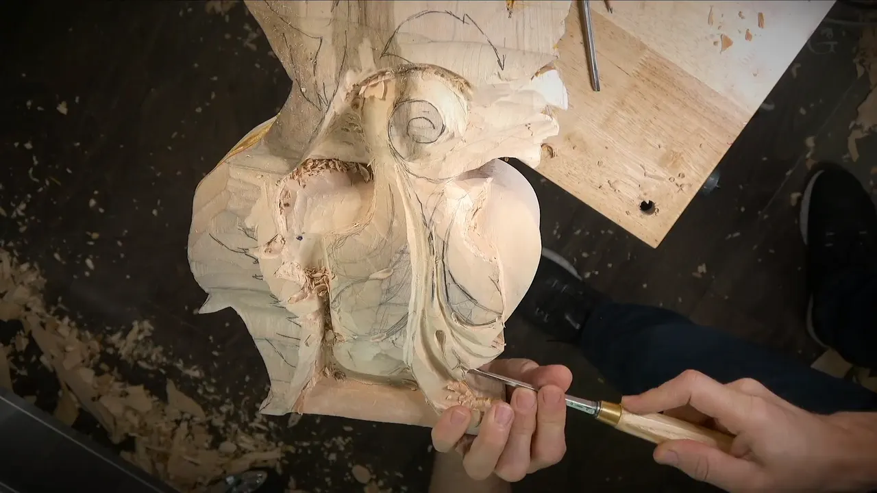 Large carved corbel with a scroll at the top, a gouge working near its lower edge
