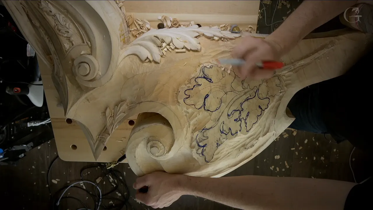 Red marker in hand above two oak leaves drawn in blue on the corbel