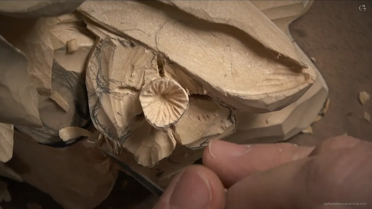 The new flower center with its uneven ridges, fingers holding a small tool just below it