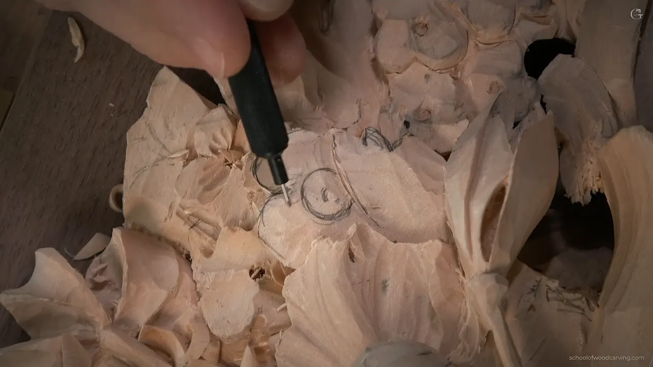 Carving a different flower beneath the parsley leaf, the tool at a small round center with almost no wood left behind it