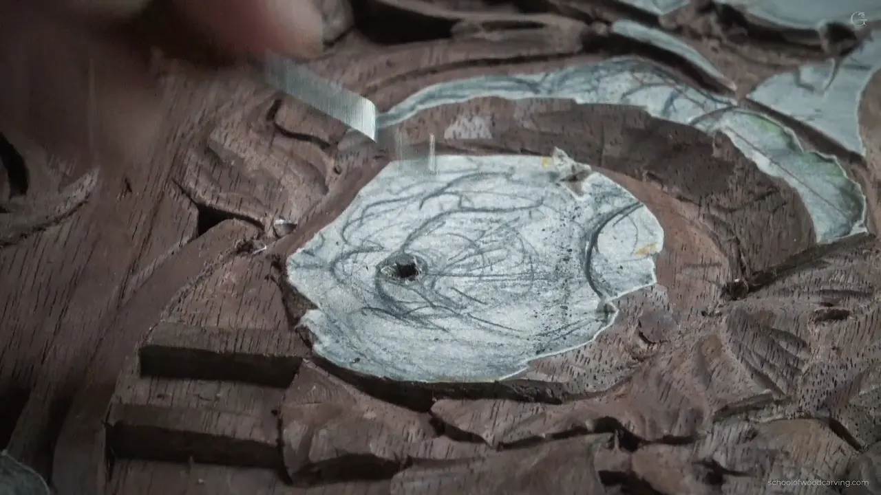 Paper pattern still glued over the bloom, a black opening already sunk through the middle of it, tool above.