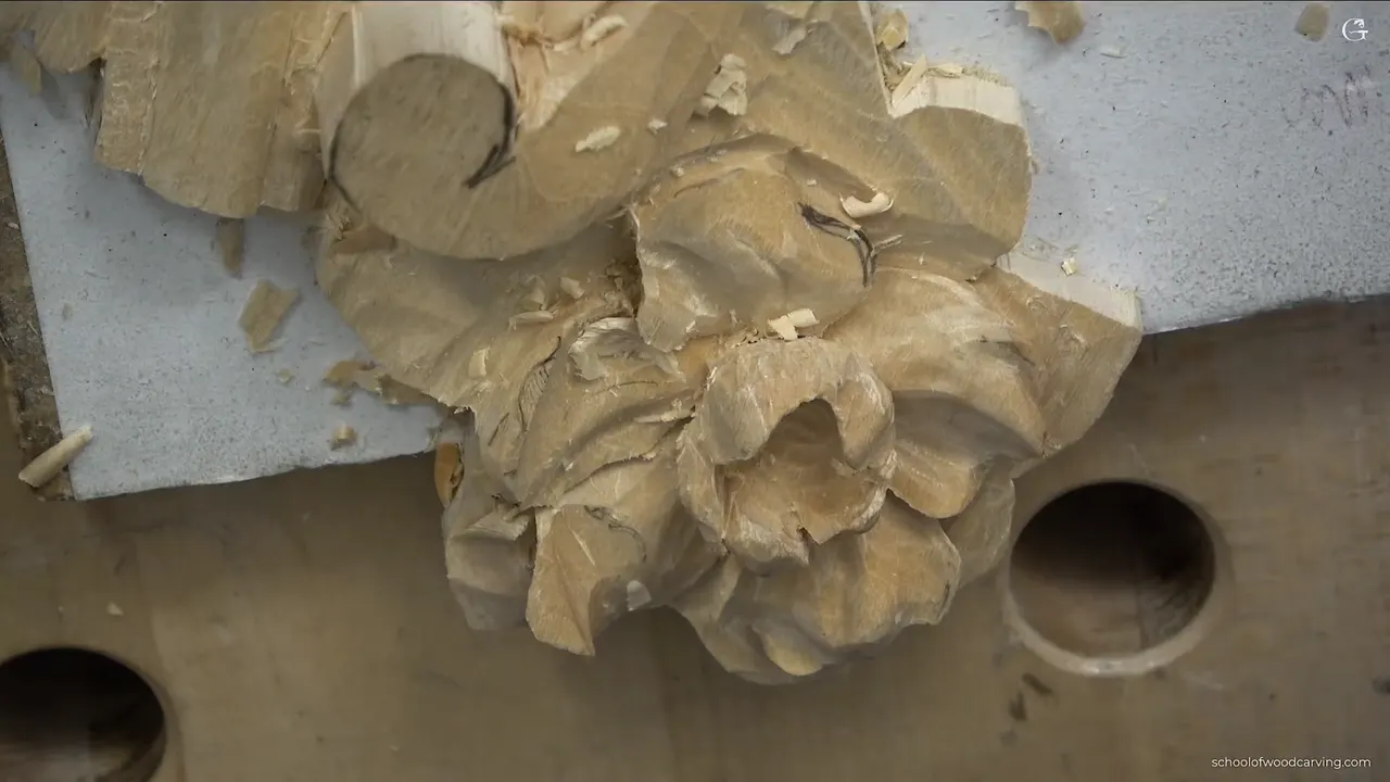 Carved rosette seen straight on, every petal shaped and the shadows already reading deep between them.