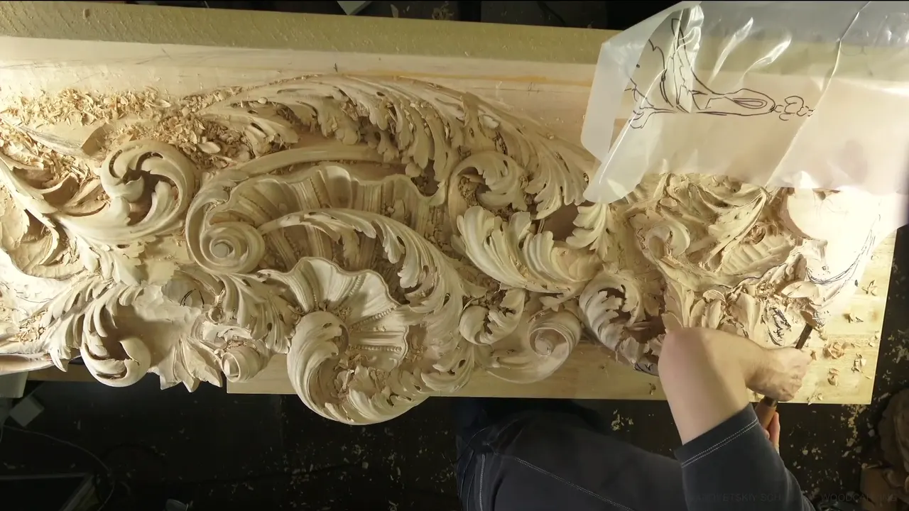 The long ceiling board from above, with a clear drawing sheet at its right end and one arm carving.