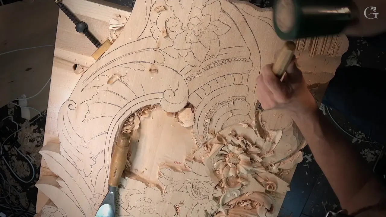 Whole panel from above, a mallet raised at the top right over a gouge