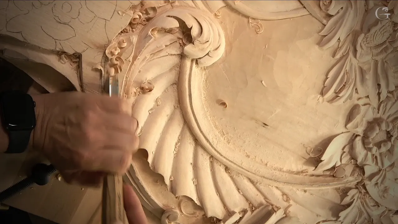 Hand and gouge at the left of the fluted shell, curled chips all around