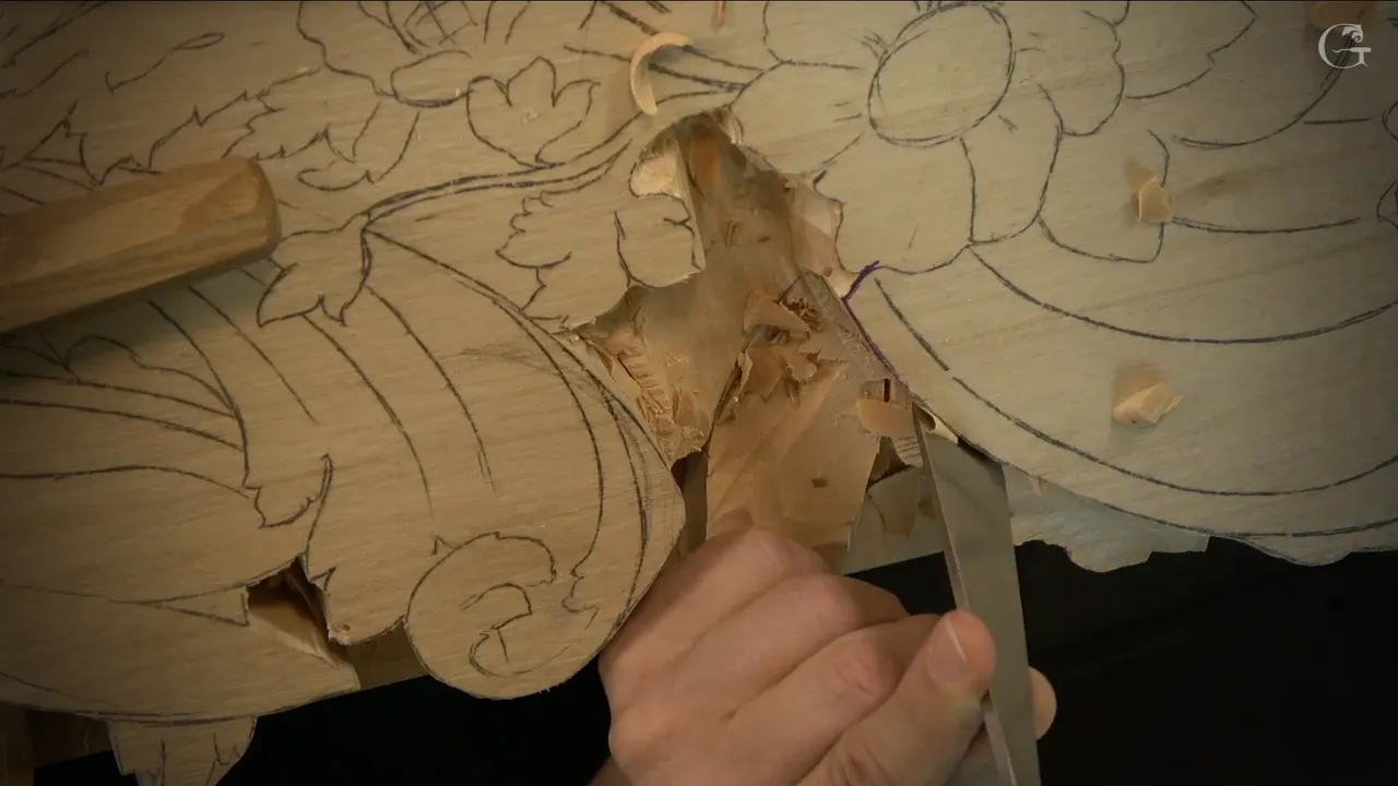 A flat chisel stands straight down at the pencil line, just below a drawn flower.