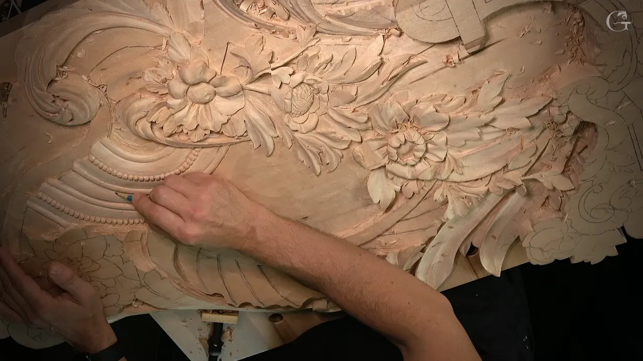 Fingers rest on a curved row of carved beads