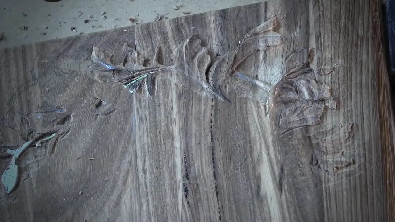 Carved leaves branch off one long stem across the dark lid at the close of this session.
