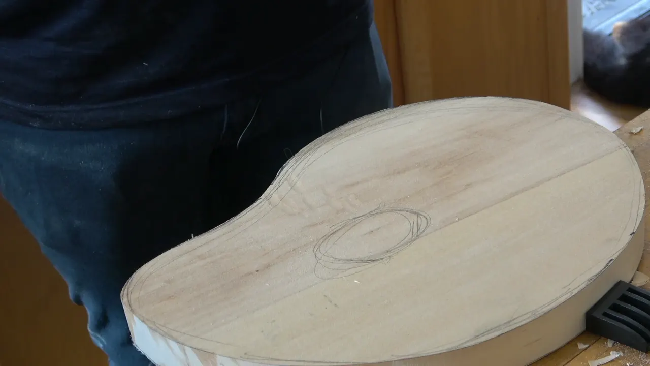 Background board with a pencil oval drawn on it, and faint layout lines running across the surface