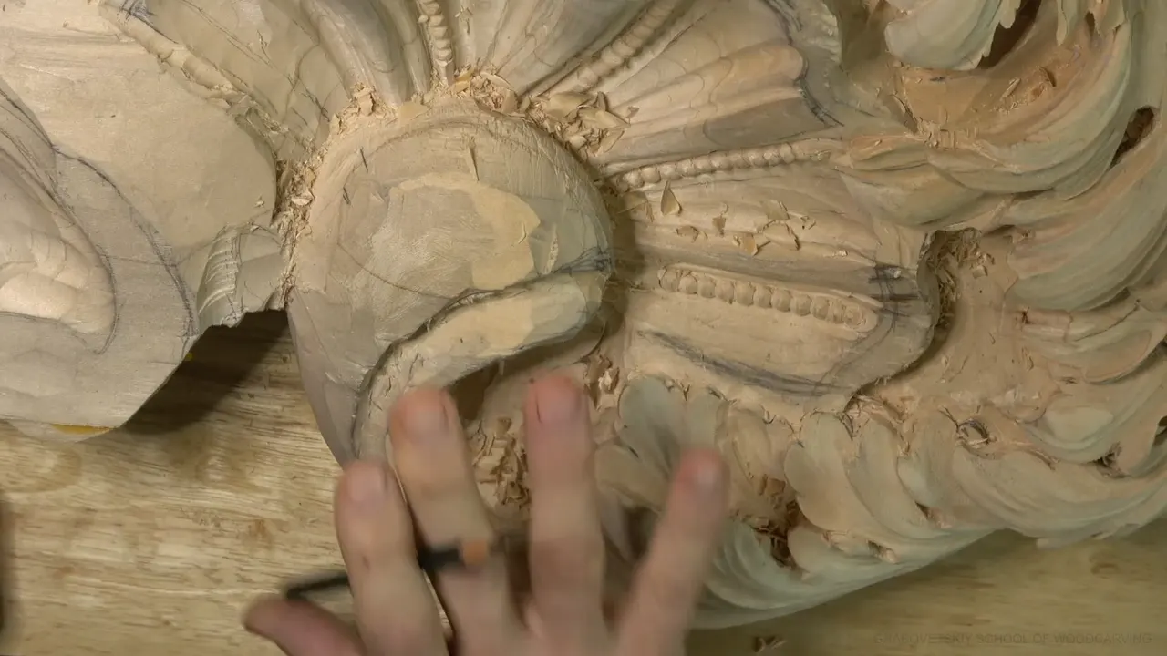 Alexander's fingers resting under the main acanthus head, the roughed dome of it filling the middle of the panel