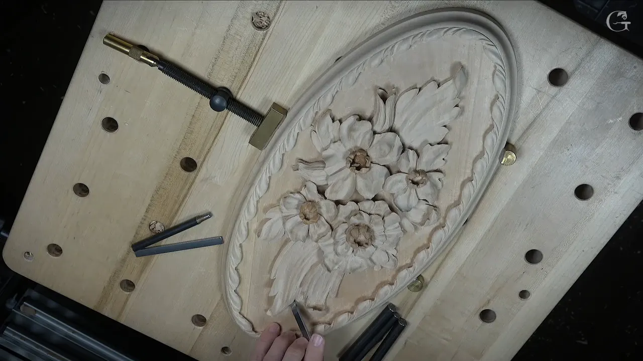Finished Venetian flowers rosette on the bench, the carved border running right round the oval and the ground punched.
