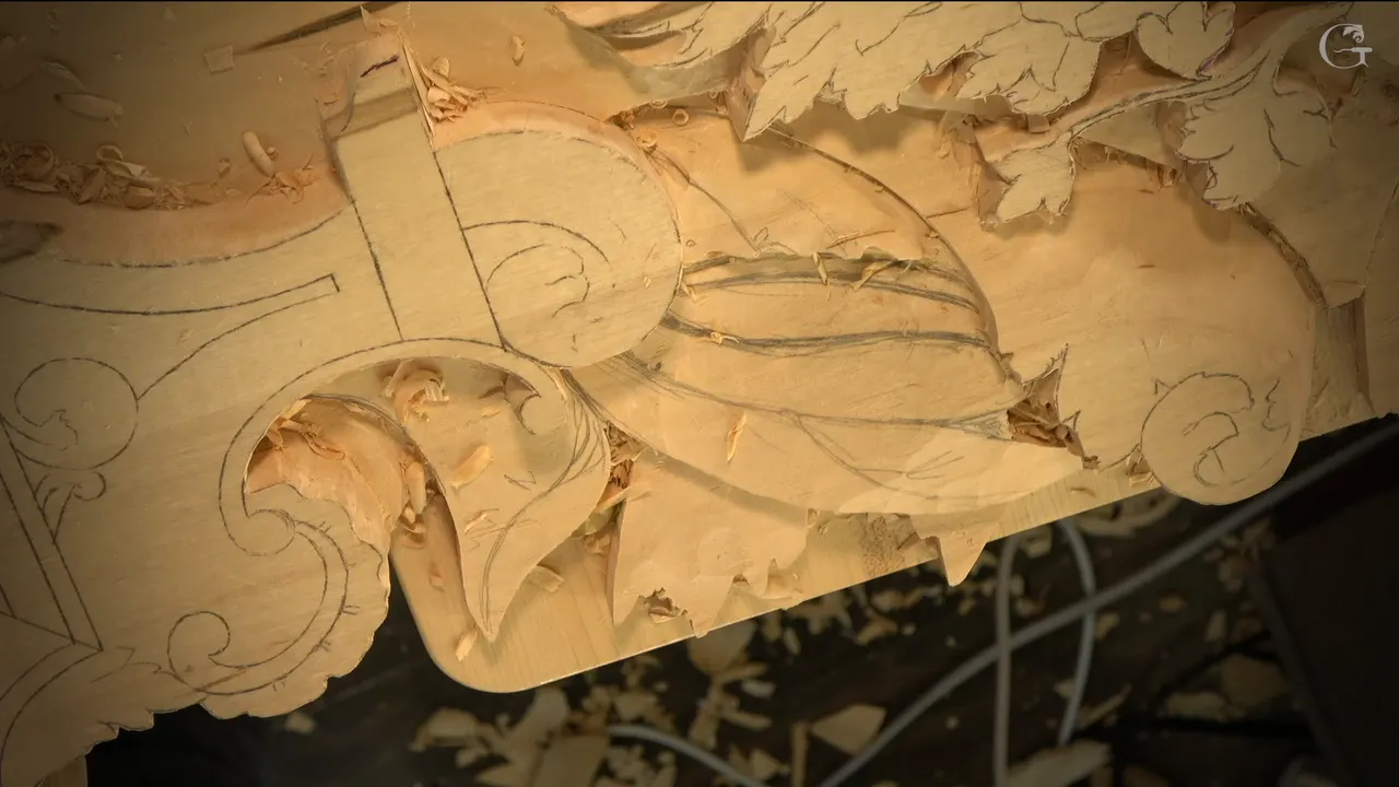A carved ray beside a scroll, a dark line of shadow along its top edge.