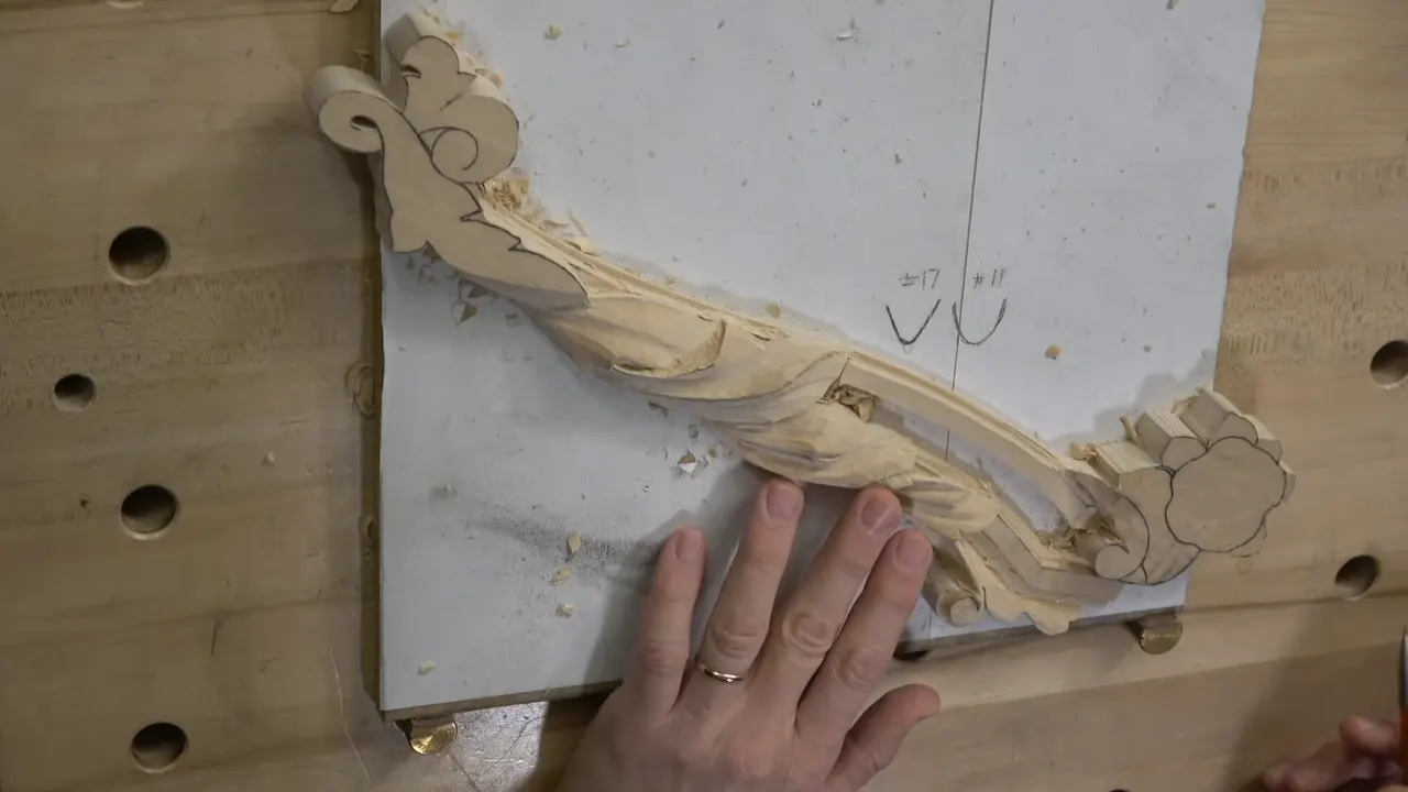 The carved swag from above with a hand resting on it, several spots still unshaped.