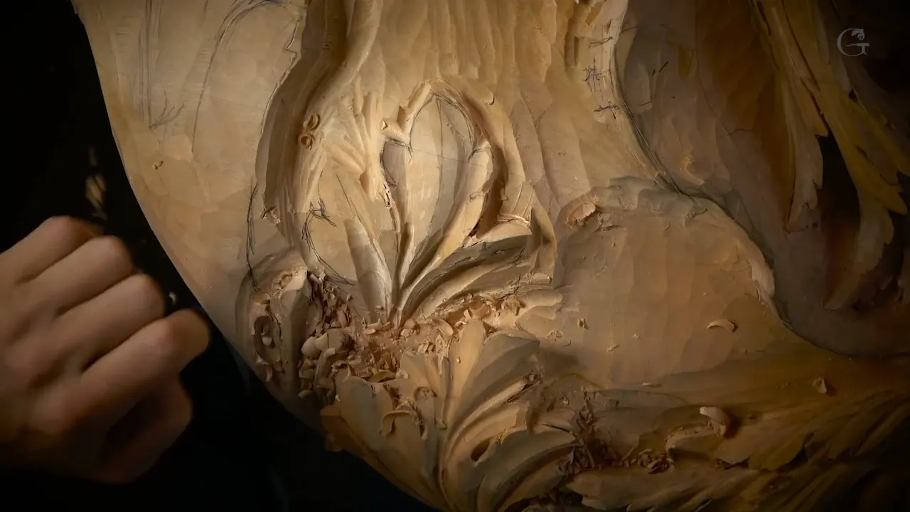 Shadows gather in the hollows of a carved leaf, one hand at the left.
