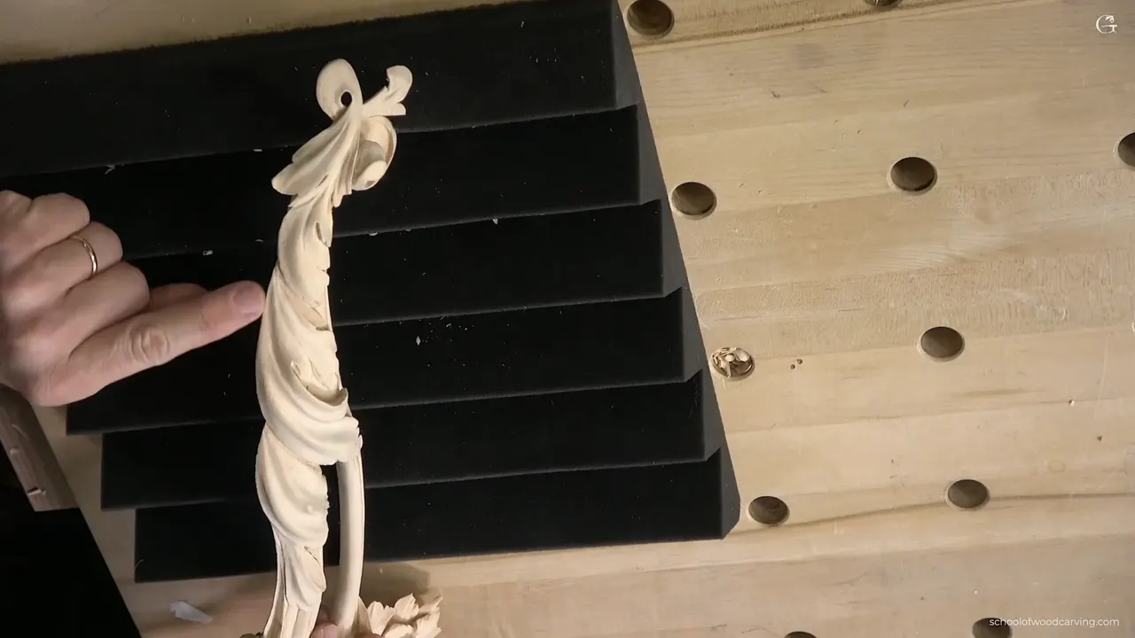 One of the four pieces standing on ribbed black foam, a finger beside it