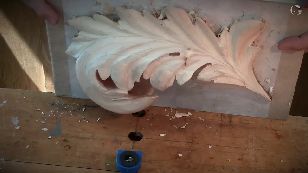 The carved leaf lifted off its board and held upright in both hands