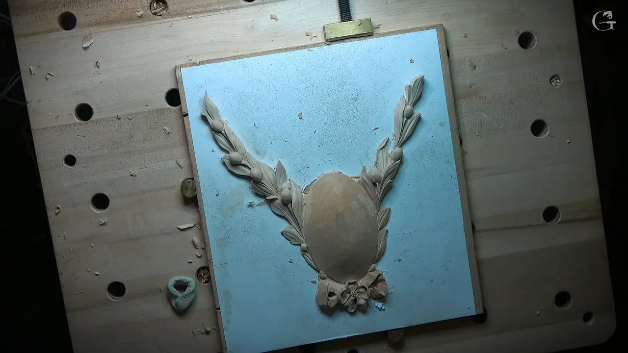 Whole rosette on a blue board, two sprays rising beside the plain oval, a lump of clay at left