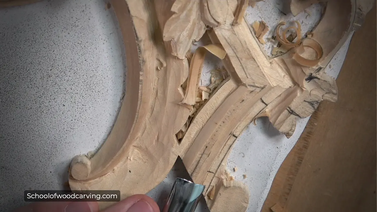 Gouge low on the molding near the scroll, curled shavings up by the corner