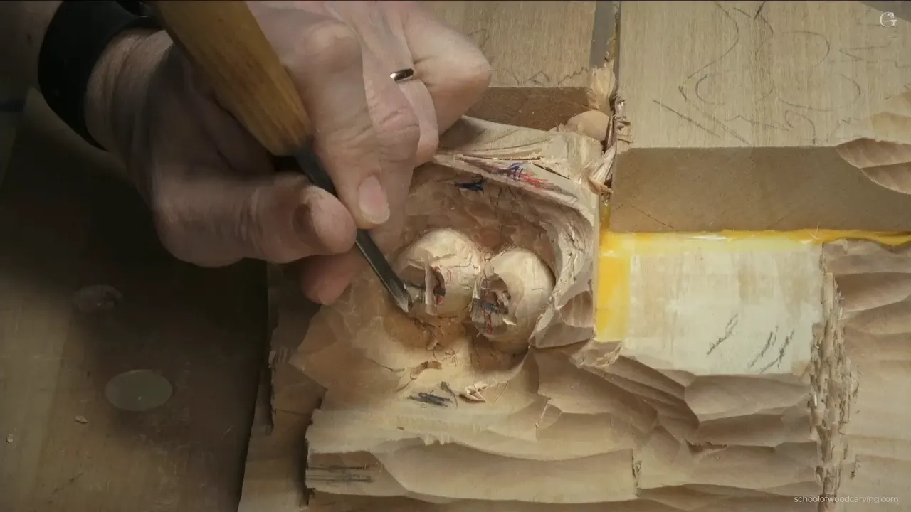 Hand guiding a thin veiner into the gap between two carved hazelnuts