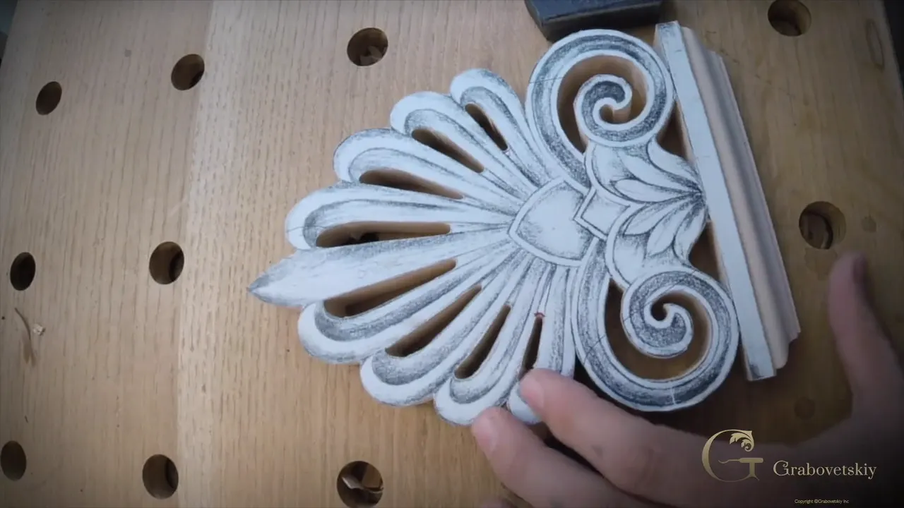 Sawn palm fan blank with its paper pattern glued on, the finished base along one side, on a bench full of round holes