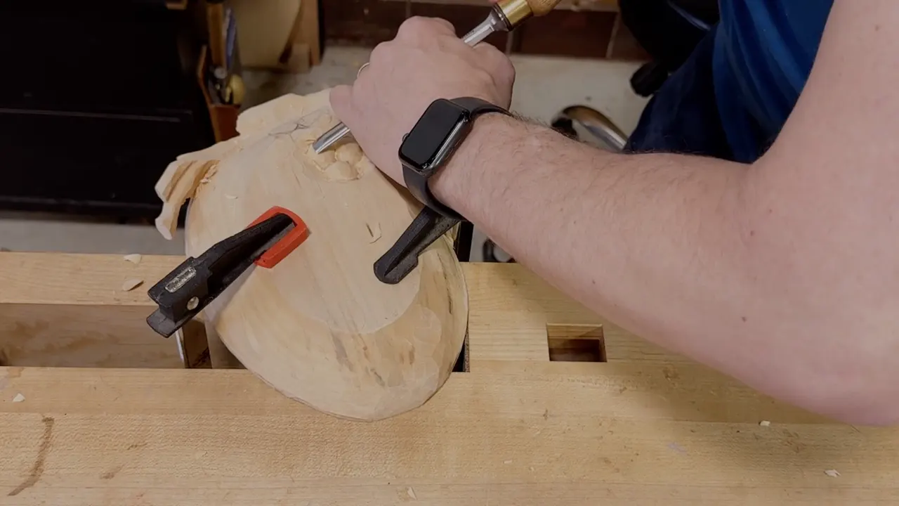 Fist on a gouge beside the rounded grapes on the underside of the clamped tray