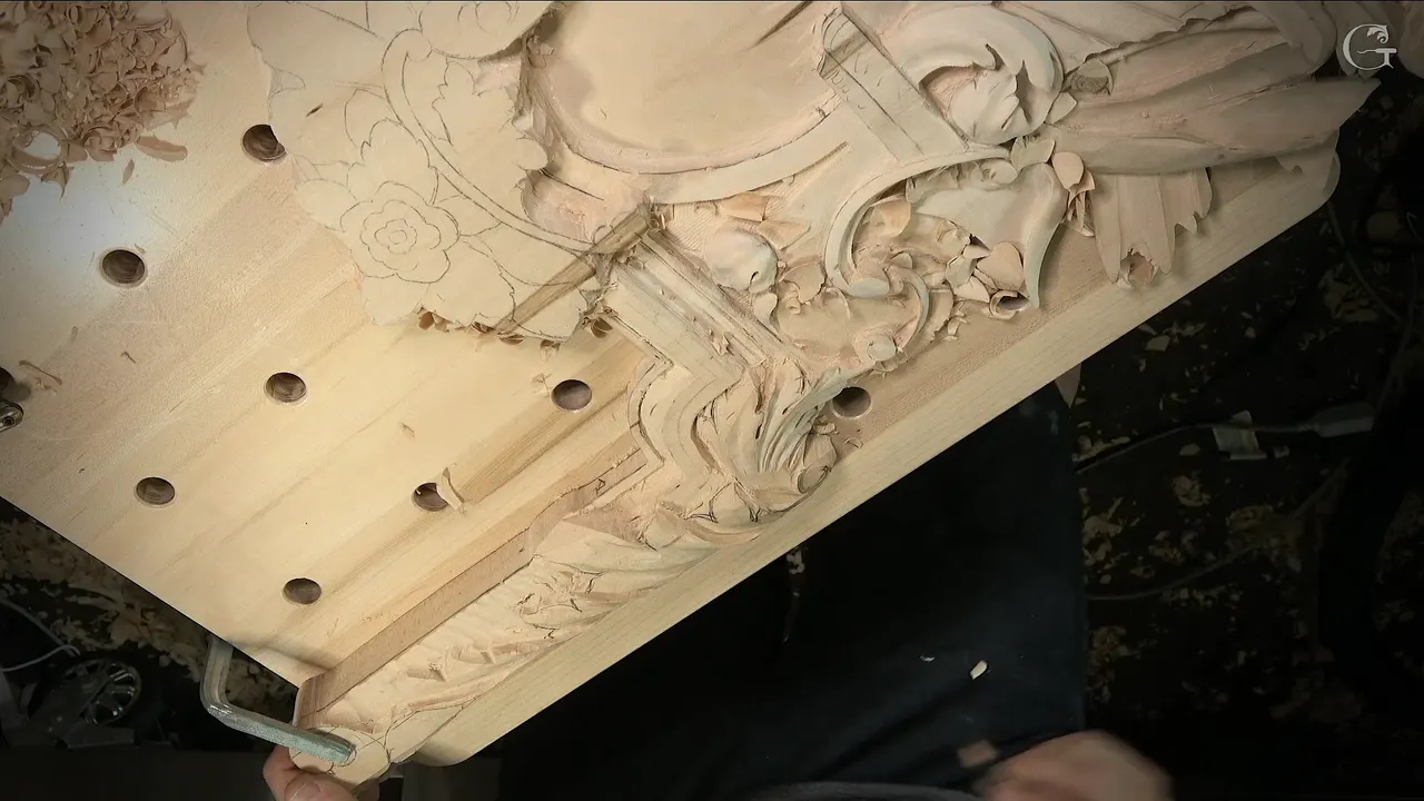 Overview of the Venetian panel from above, a pencil rosette still waiting beside the carved scrolls and molding