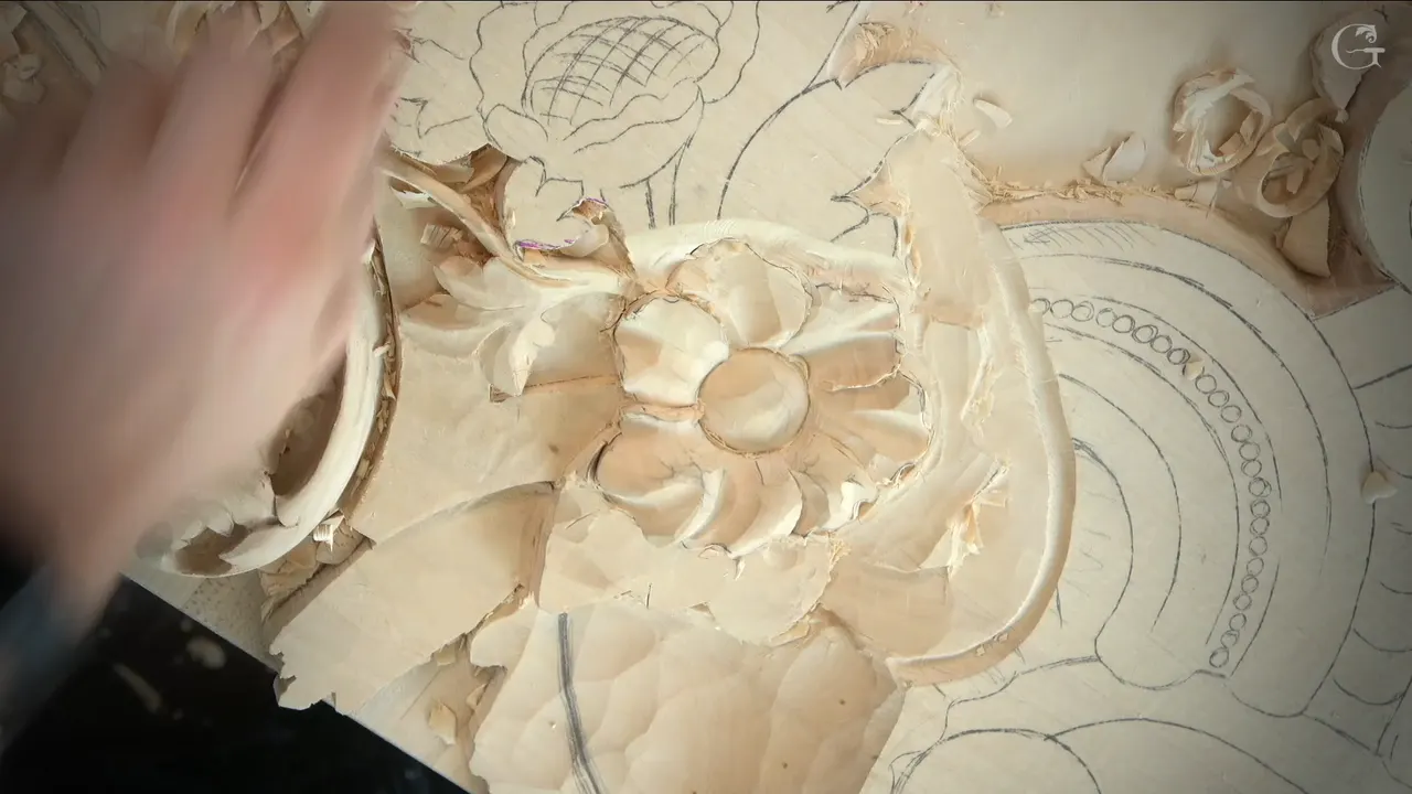 Venice Room relief flower from above, a round raised middle and hollowed petals, a blurred hand at the left