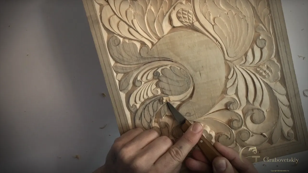 Knife tip at a curl near the bottom of the wing, with chips lying on the bench around the board